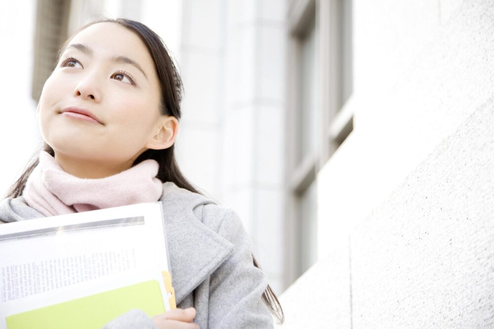 書類を持っている学生（女）