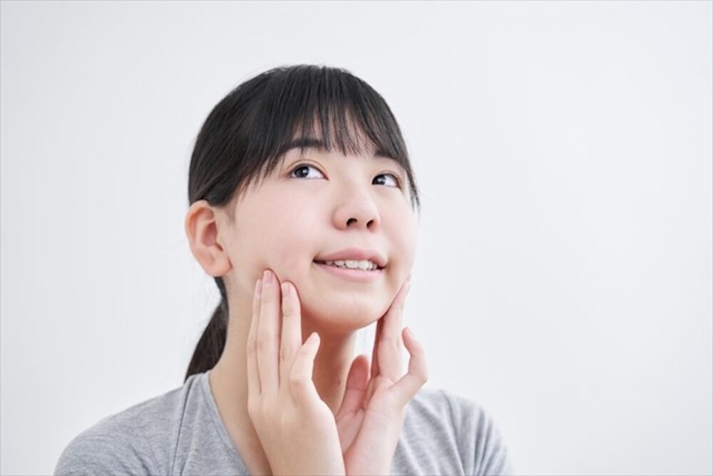 頬をおさえる女性