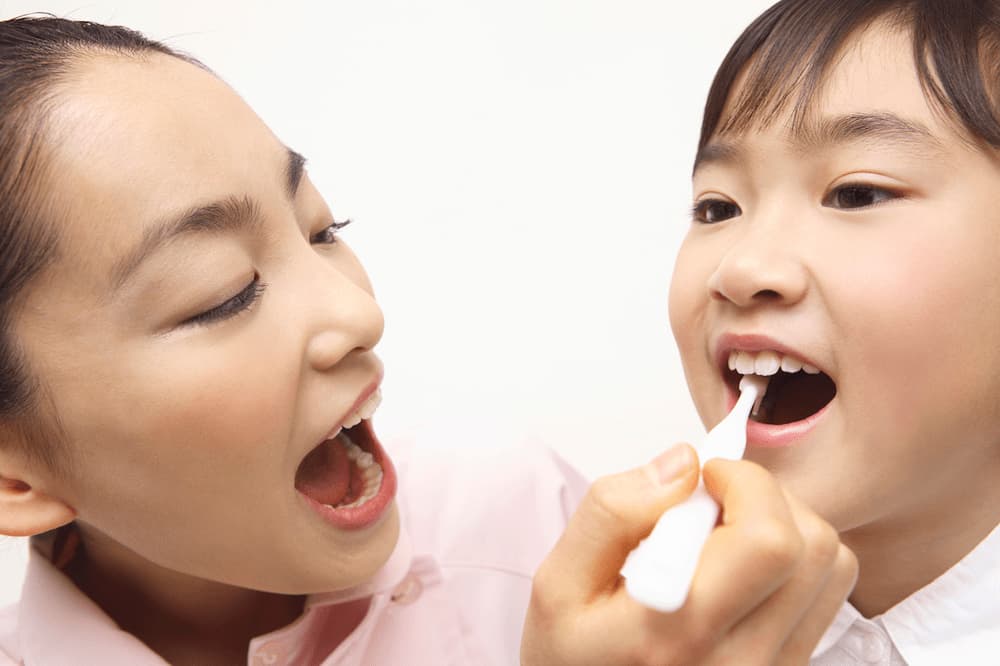 仕上げ磨きをする子ども